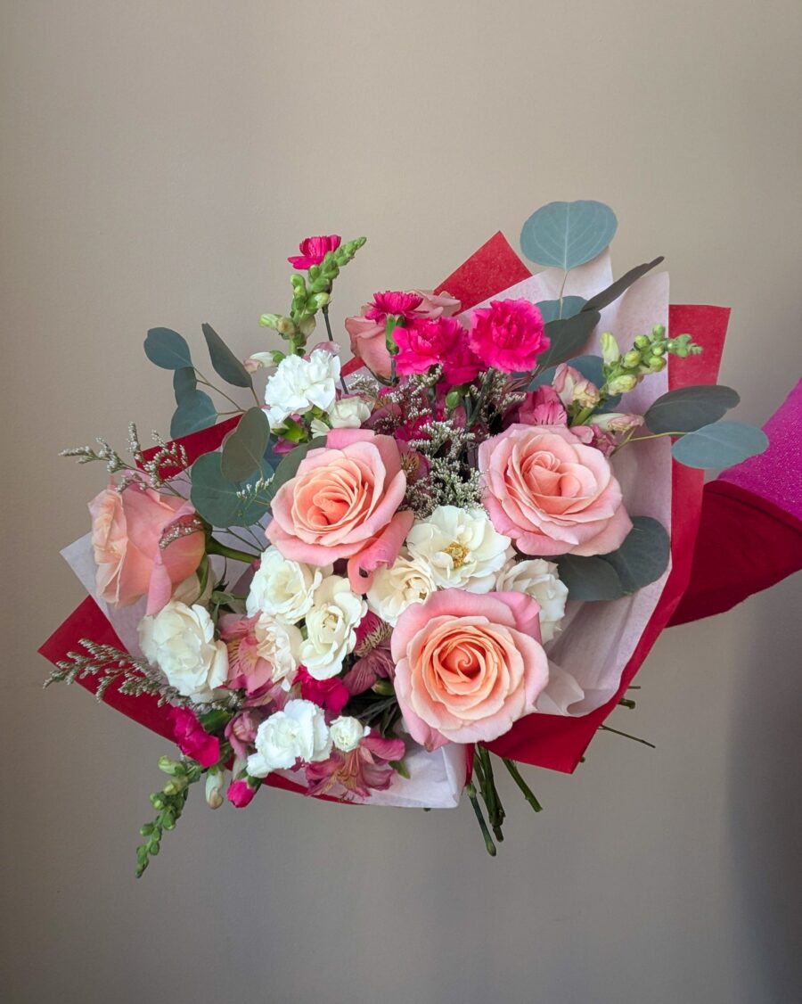 St. Louis Valentine's Day bouquet featuring pink and white flowers wrapped in red and pink tissue paper.