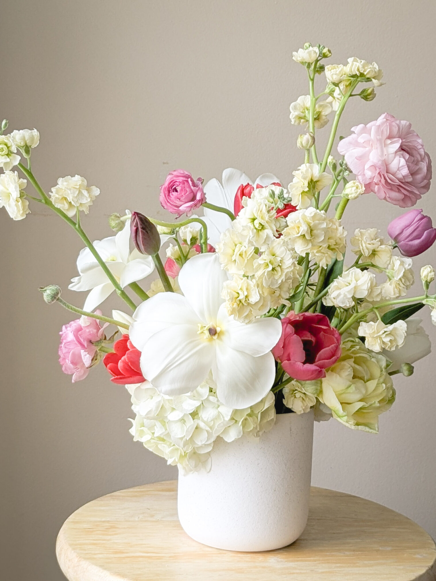 PXL_20250409_200219537 Spring flower arrangement featuring tulips, ranunculus, hydrangea, and stock.